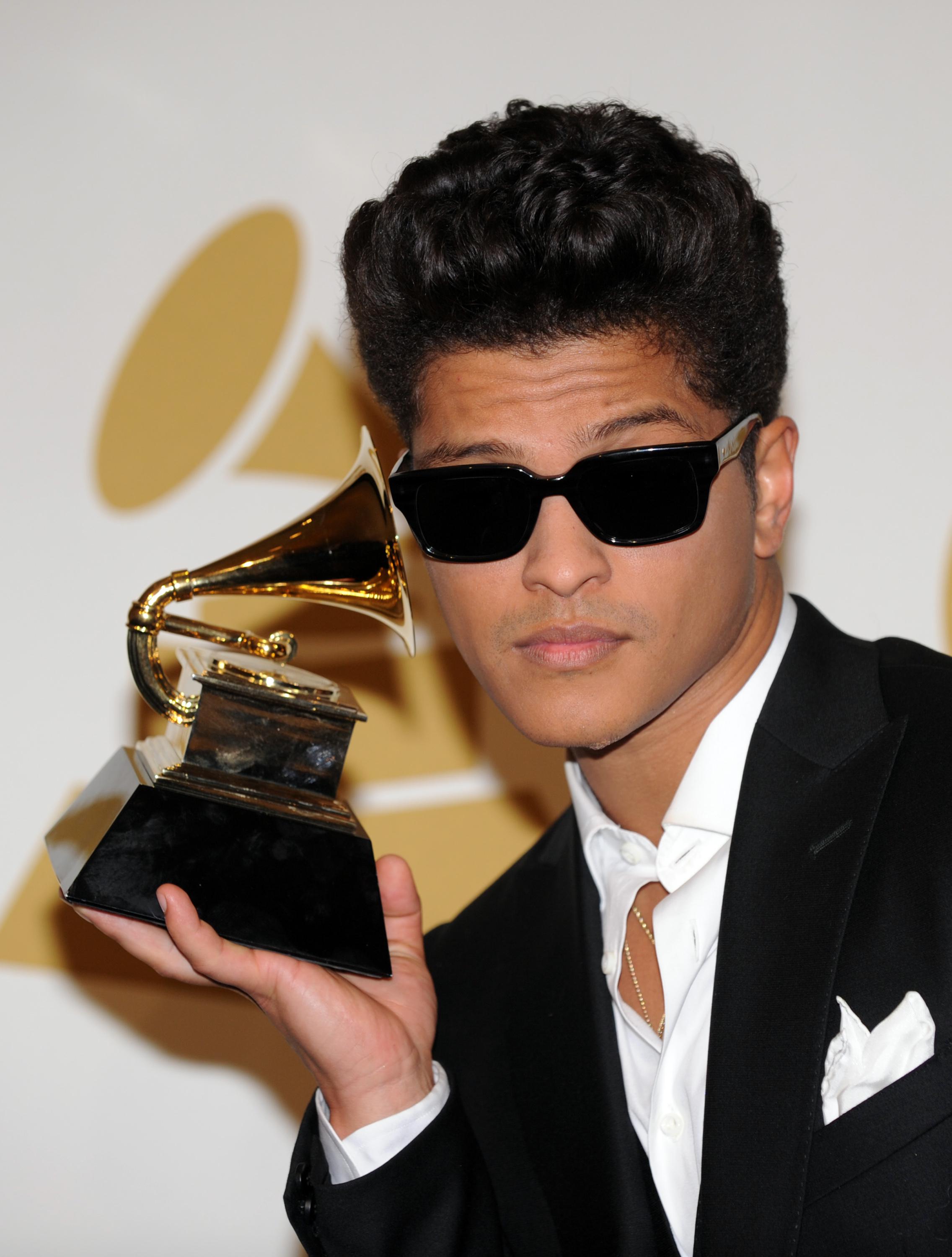 Bruno Mars poses with is award during th